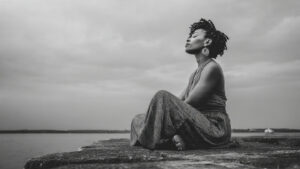 Black woman sitting dealing with imposter syndrome
