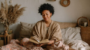 Black woman reading comfortably in bed as part of a calm, intentional reading routine